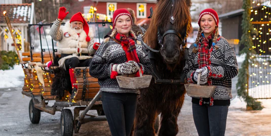 Nissefar og to nissejenter sammen med hest og kanefart