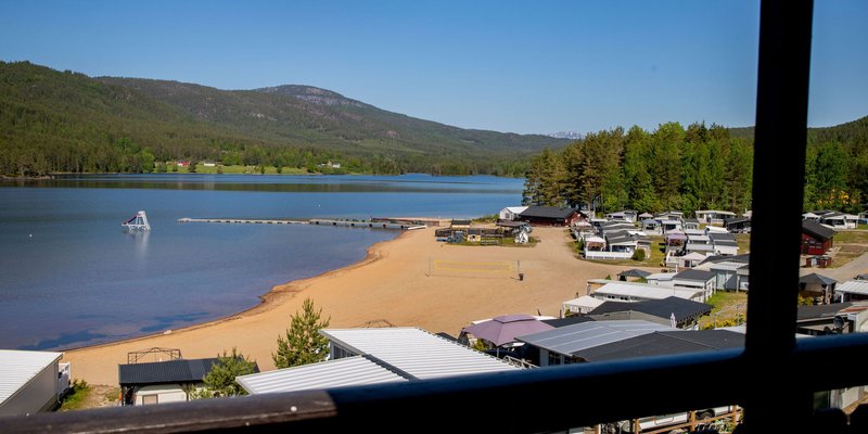 Bildet er et oversiktsbilde over Kilen Camping med strand og hytter/campingvogner