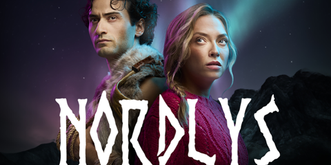 Teaterplakat for «Nordlys» med to personer rygg mot rygg i forgrunnen, nordlys og tre ulvehoder med glødende øyne i bakgrunnen, samt tekst om forestillingen og hovedrollene.