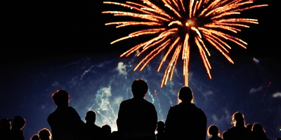 Fyrverkeri med mennesker i bakgrunn som ser på